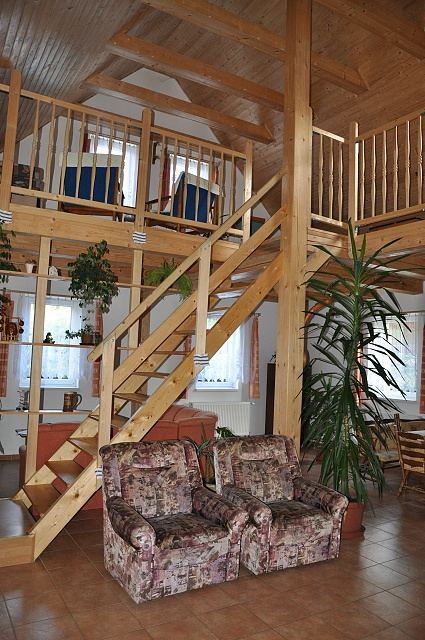 Dřevěné schodiště a galerie nad společenskou místností